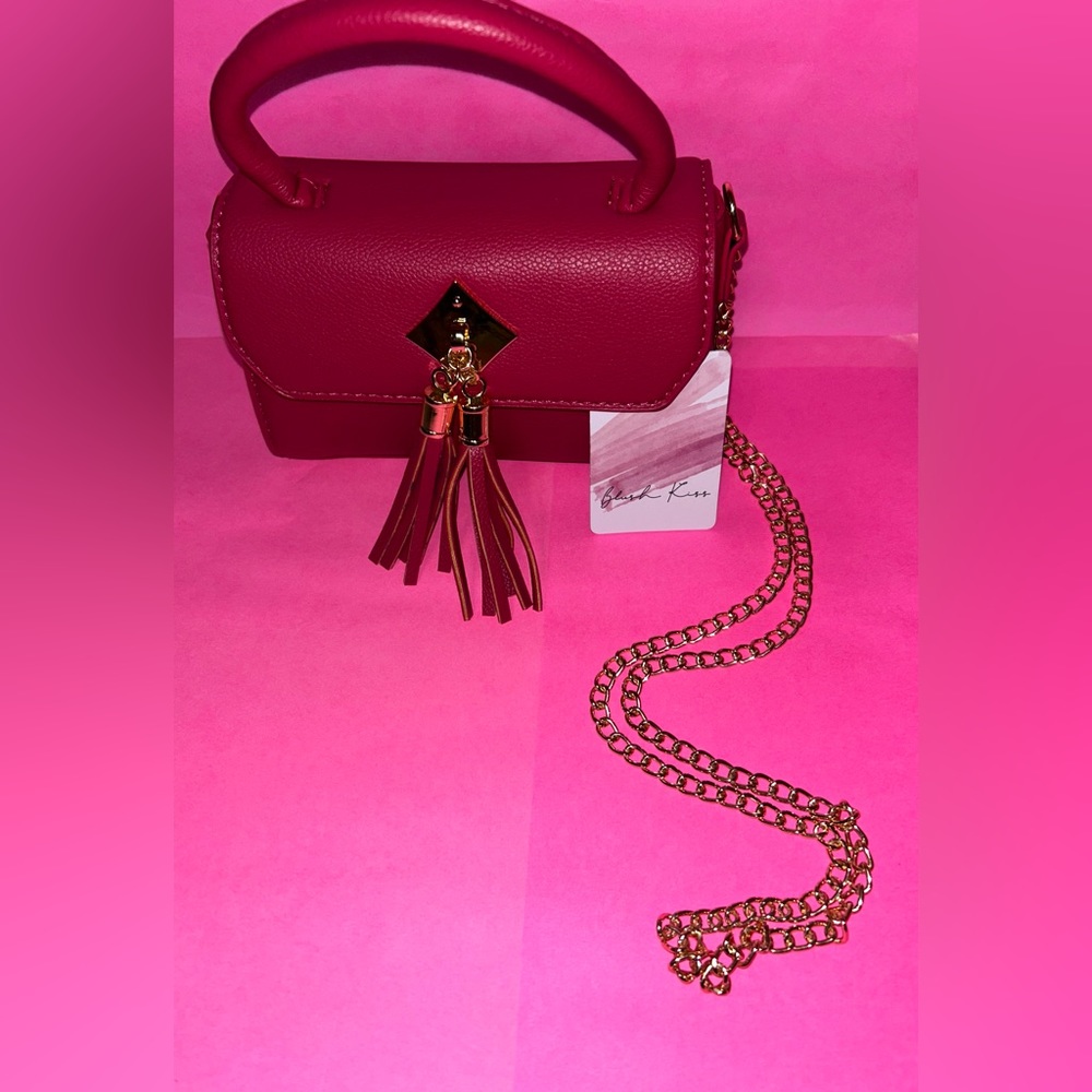 Small Blush Kiss pink bag with a gold chain strap.
